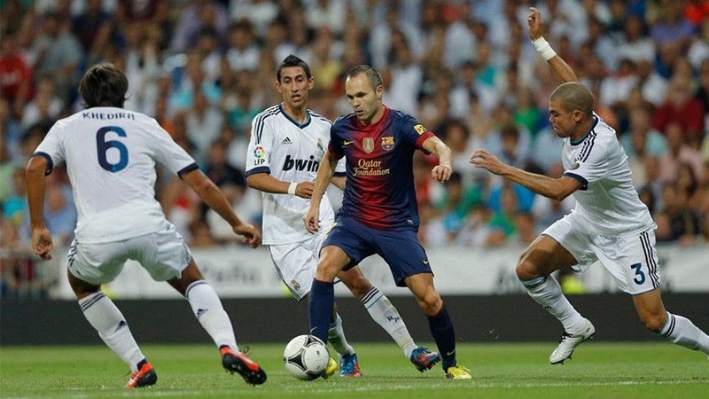 Andres Iniesta (tengah) saat bermain untuk Barcelona melawan Real Madrid.